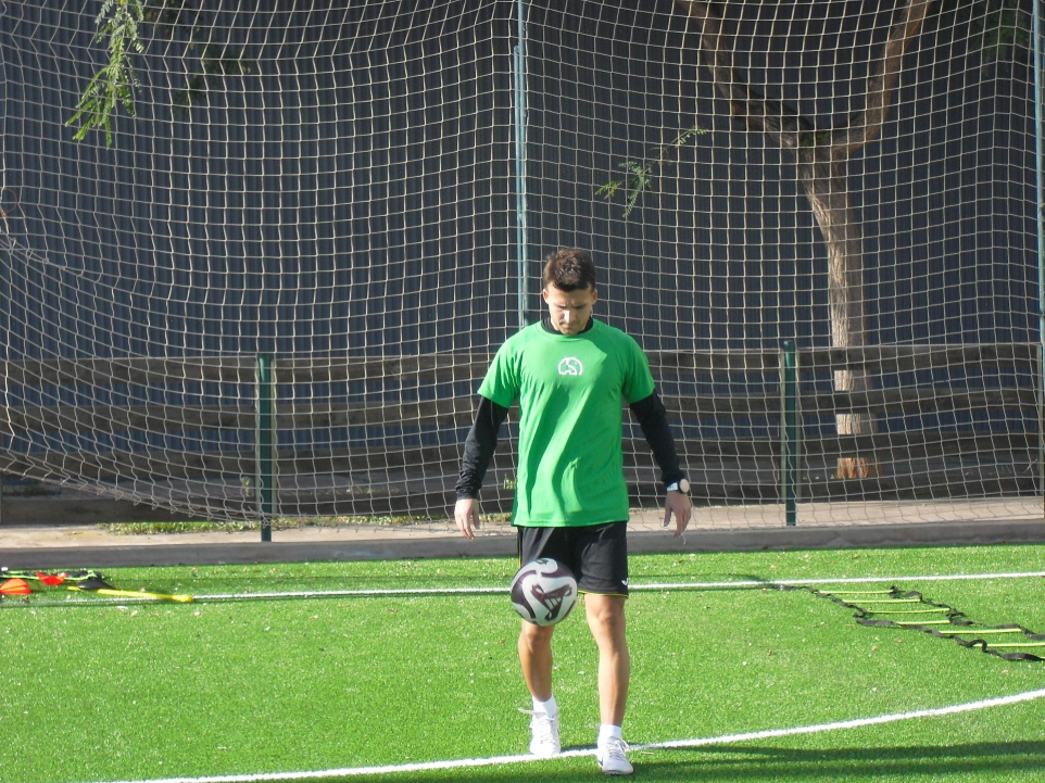 Jugador de Slon Sports Academy entrenando en el campo con portería de fondo