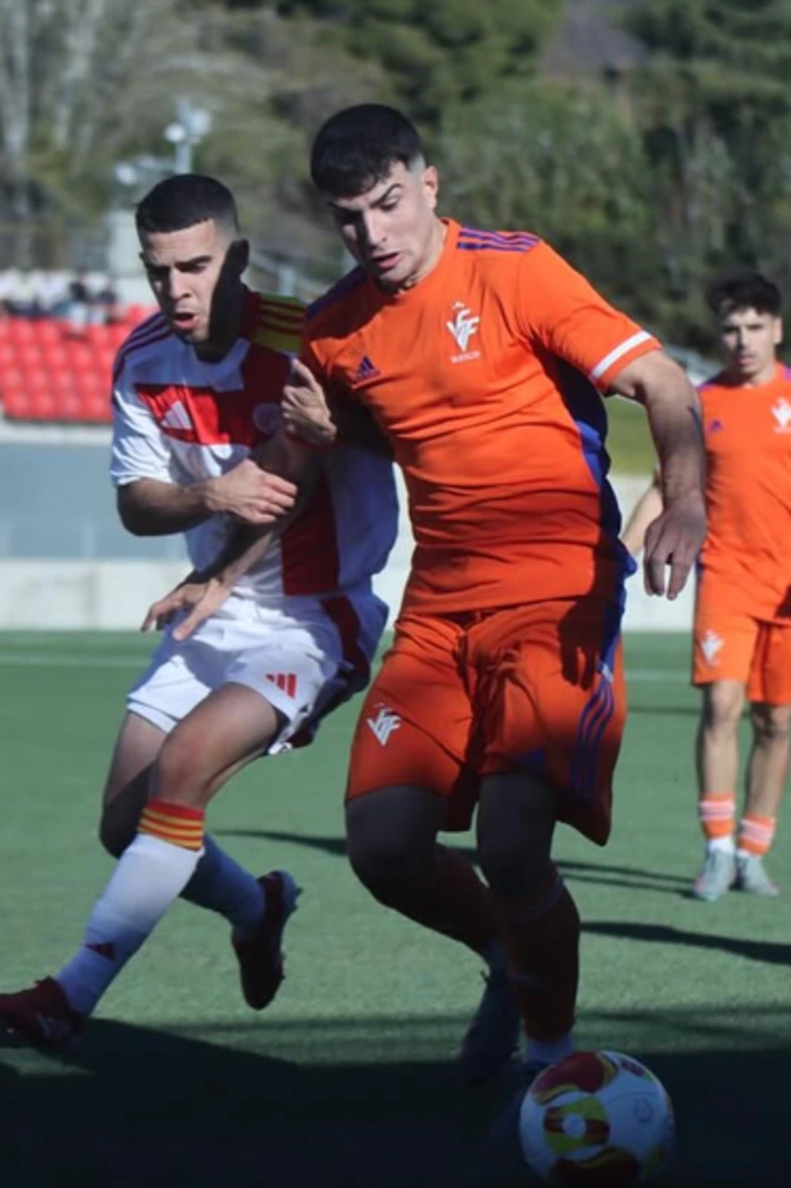Partido de fútbol profesional en acción con jugadores compitiendo por el balón